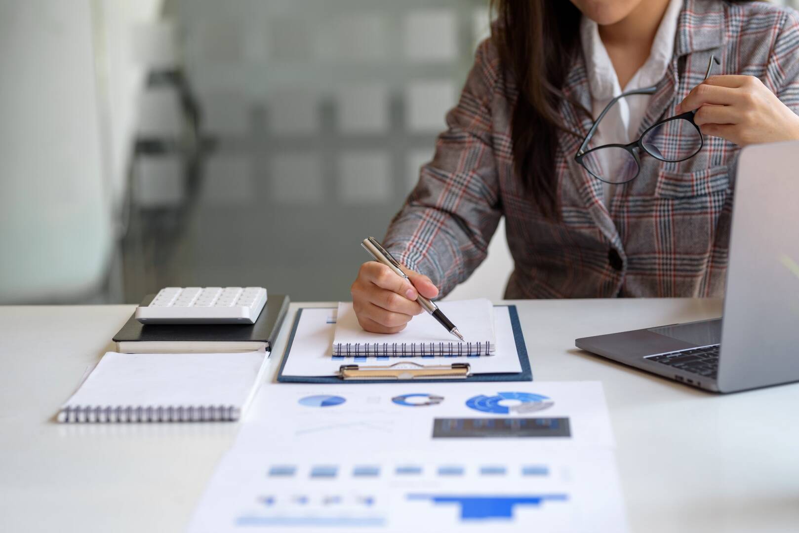 Business woman working with financial report and laptop computer in the office.