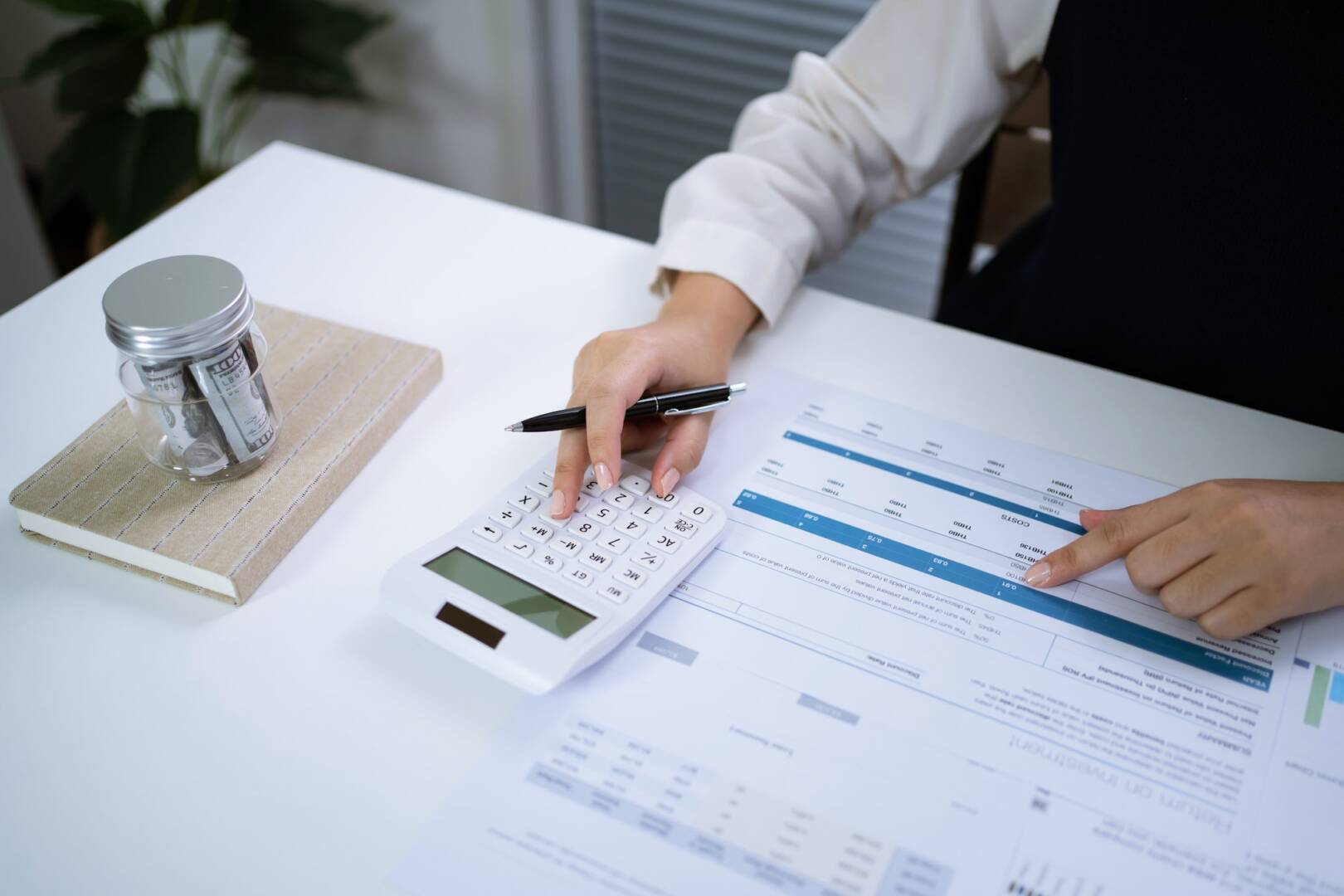 Businesswoman Accountant analyzing investment charts Invoice and pressing calculator buttons